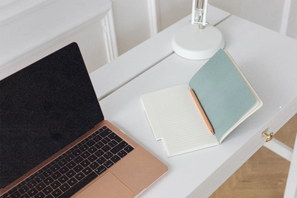How Much Does a Website Cost? An Honest Pricing Guide 1 Desk with laptop and open notebook, planning how much does a website cost