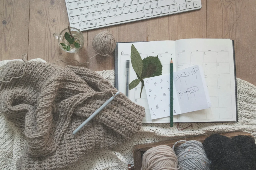 Crochet work and open planner on a cozy desk, image for the blog post "it's just a hobby, do I need a website?"